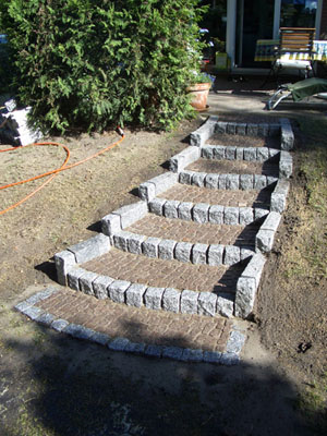 Treppe mit Stufen aus Mosaikpflaster und Wangen aus Granitstelen